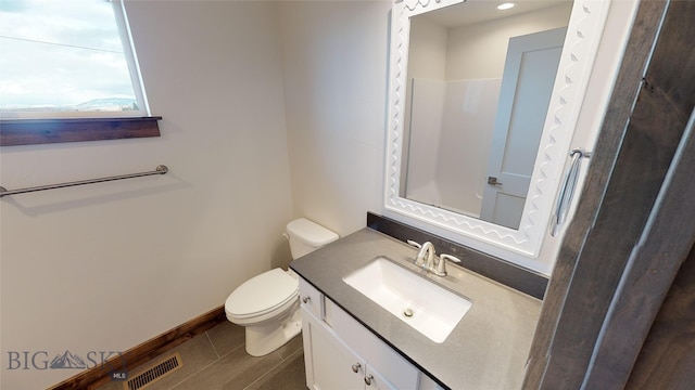 bathroom with tile patterned flooring, vanity, and toilet