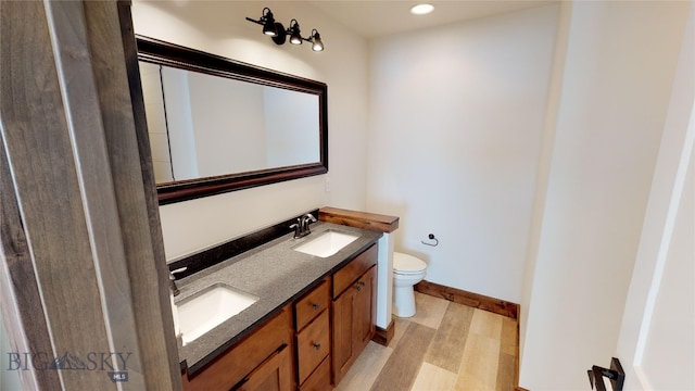 bathroom featuring hardwood / wood-style flooring, vanity, and toilet