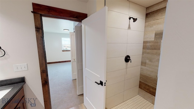 bathroom featuring tiled shower and vanity