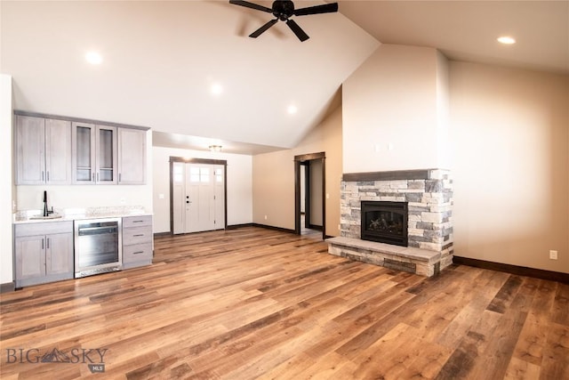 kitchen featuring wine cooler, a fireplace, light countertops, and gray cabinetry