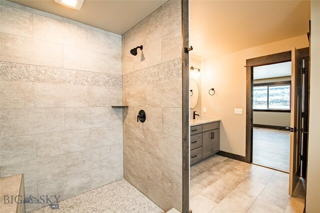 bathroom with vanity and a tile shower