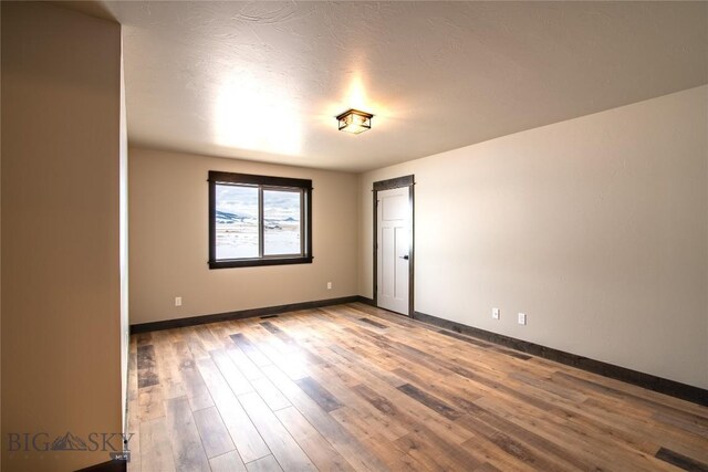 unfurnished room with baseboards and wood finished floors