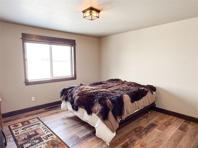 bedroom featuring baseboards and wood finished floors