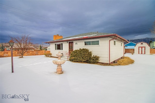 ranch-style home with a storage unit