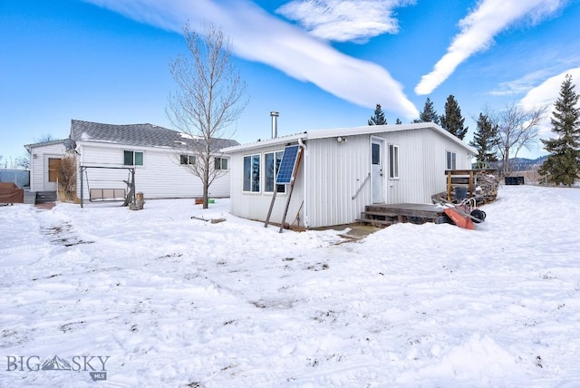 view of snow covered back of property