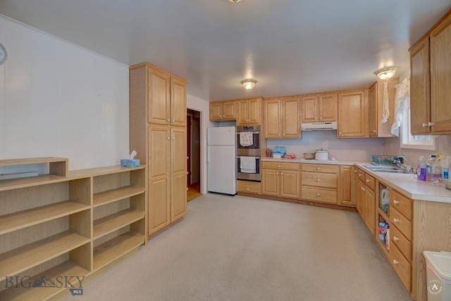 kitchen with sink, white refrigerator, light carpet, stainless steel double oven, and light brown cabinets