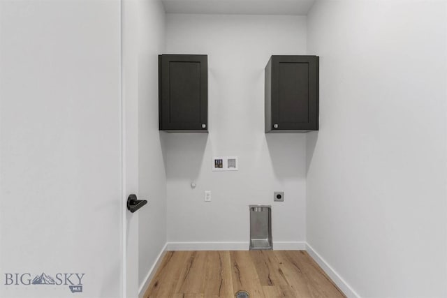 clothes washing area with electric panel, cabinets, washer hookup, wood-type flooring, and hookup for an electric dryer