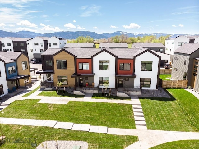 back of property featuring a mountain view and a yard