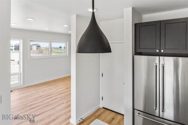 kitchen with high end fridge and light hardwood / wood-style floors