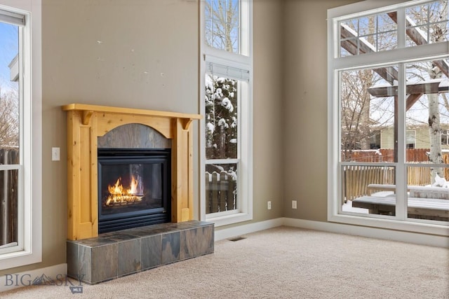 unfurnished living room featuring a tile fireplace and carpet