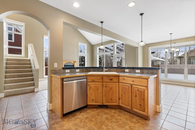 kitchen featuring sink, hanging light fixtures, light tile patterned flooring, vaulted ceiling, and stainless steel dishwasher