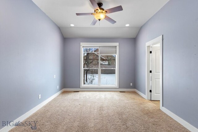 carpeted spare room with ceiling fan and lofted ceiling