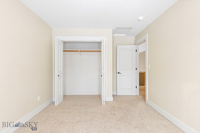 unfurnished bedroom with a closet and light carpet