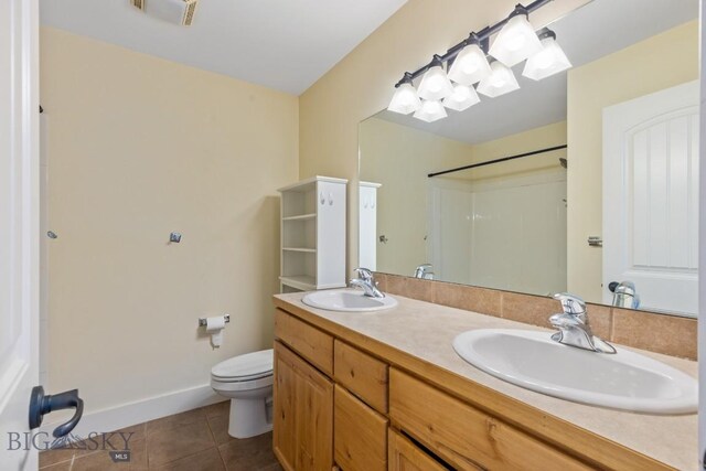 bathroom featuring tile patterned flooring, vanity, and toilet