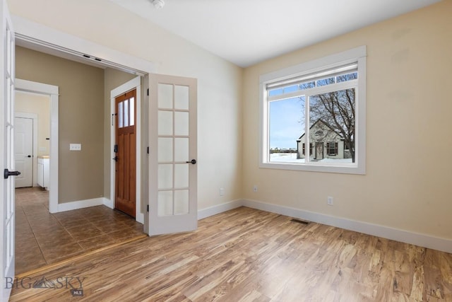 spare room featuring hardwood / wood-style flooring and vaulted ceiling