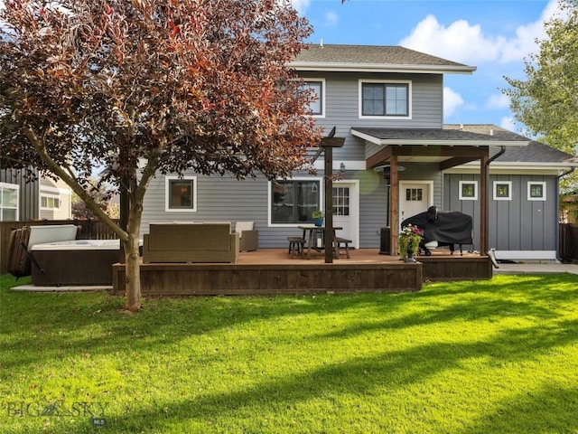 rear view of property with a yard, a hot tub, and a deck