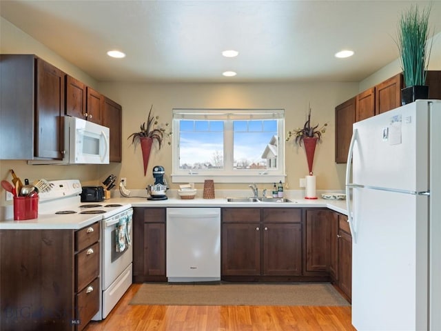 kitchen with white appliances, sink, and light hardwood / wood-style flooring