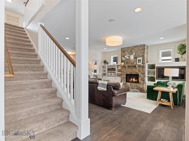 living room with dark wood-type flooring and a fireplace