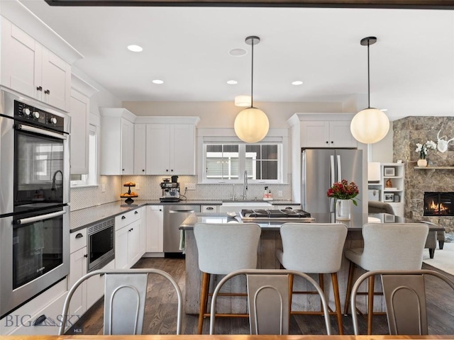 kitchen with white cabinetry, stainless steel appliances, and pendant lighting