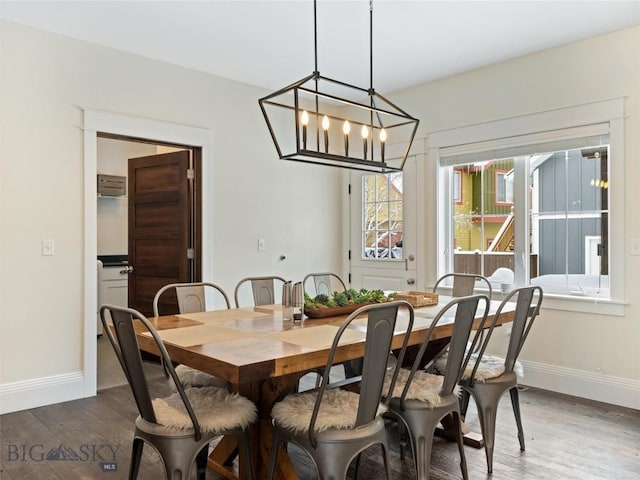 dining space featuring dark hardwood / wood-style floors and a chandelier