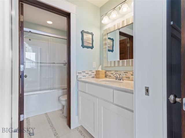 full bathroom with tile patterned floors, toilet, tasteful backsplash, shower / bath combination with glass door, and vanity