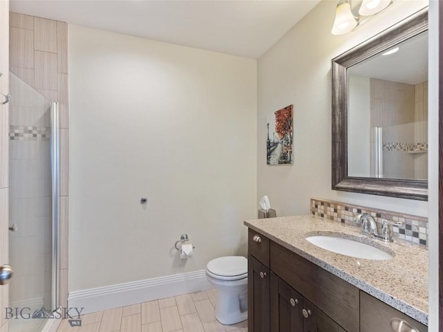 bathroom featuring tasteful backsplash, toilet, vanity, and walk in shower