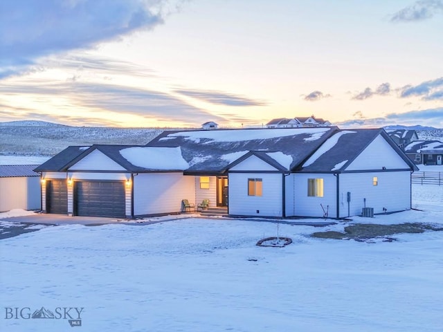 view of front of property with cooling unit, a garage, and a mountain view