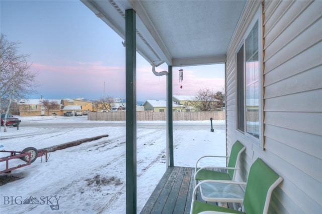 snow covered deck with a porch