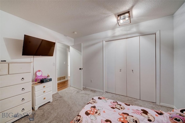 unfurnished bedroom with a closet, light carpet, and a textured ceiling