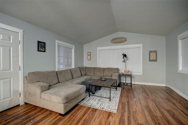 living room featuring hardwood / wood-style flooring, lofted ceiling, and a textured ceiling