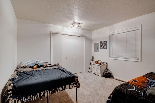 carpeted bedroom featuring a closet and a textured ceiling