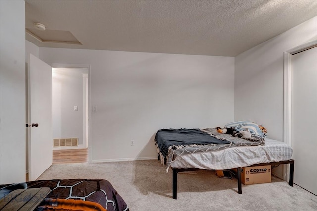 bedroom with carpet and a textured ceiling