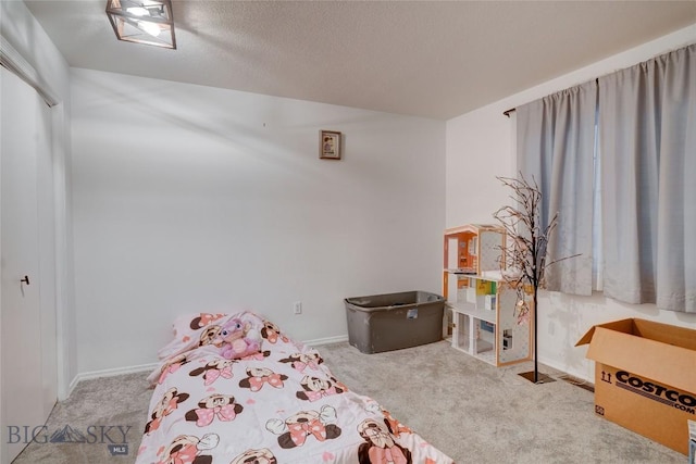 bedroom with carpet floors, a textured ceiling, and a closet