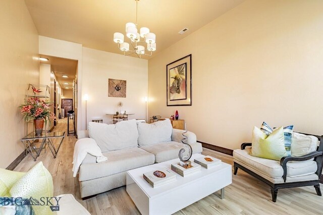 living room with wood-type flooring and a chandelier