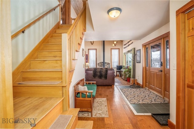 entrance foyer with hardwood / wood-style floors and a wood stove