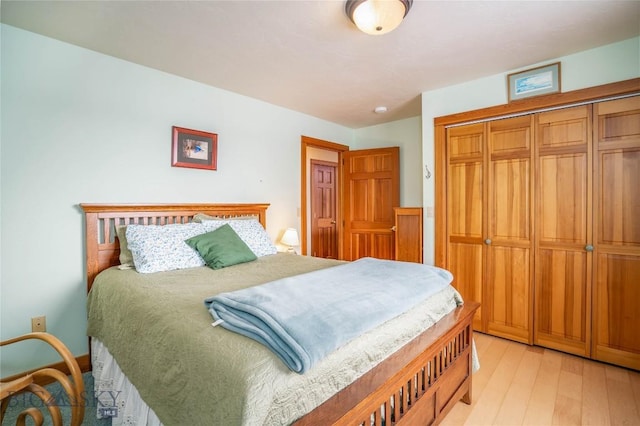 bedroom with light hardwood / wood-style floors and a closet