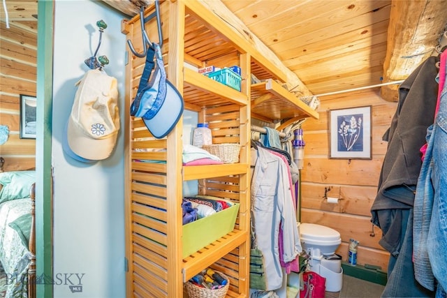 bathroom with toilet, wooden walls, and wooden ceiling