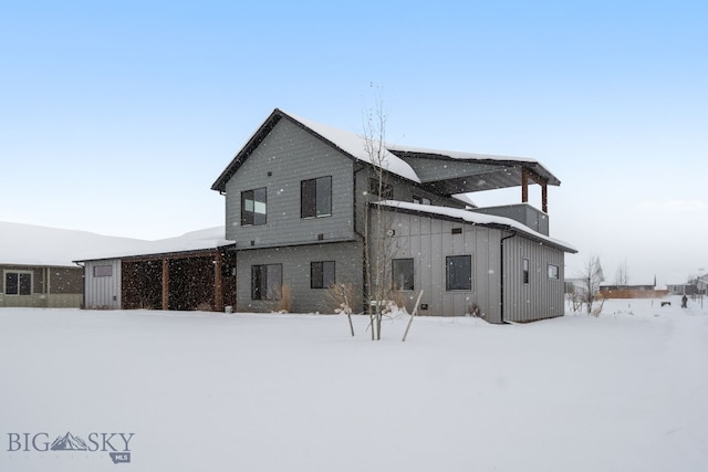 view of snow covered back of property