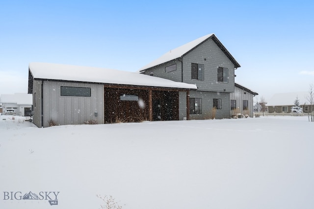 view of snow covered rear of property