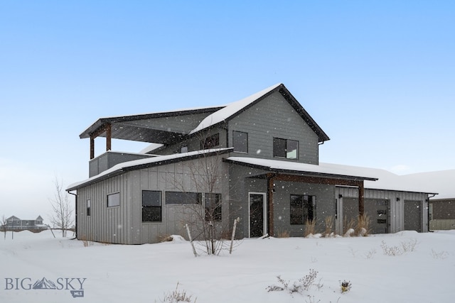 view of snow covered rear of property