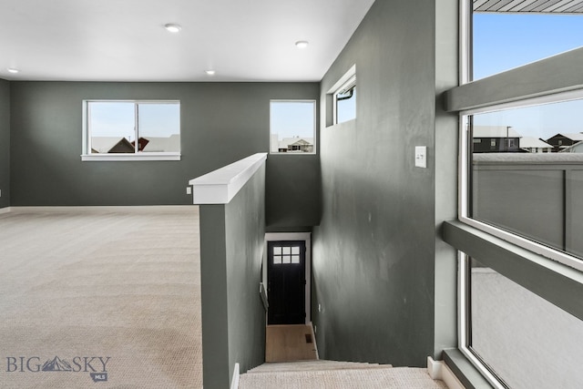 stairs featuring a towering ceiling, carpet flooring, and a wealth of natural light