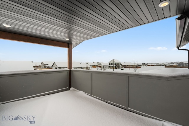 view of snow covered back of property