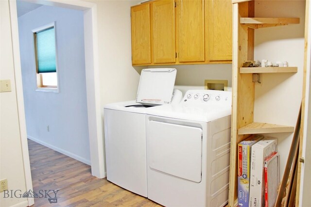 washroom with cabinets, washer and dryer, and light hardwood / wood-style flooring