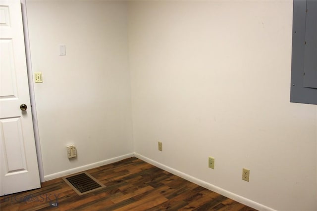 spare room featuring dark wood-type flooring and electric panel