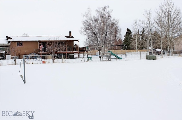 yard covered in snow with a playground