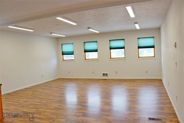 unfurnished room featuring dark hardwood / wood-style floors and a textured ceiling