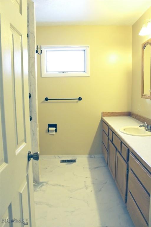 bathroom with marble finish floor, visible vents, and vanity