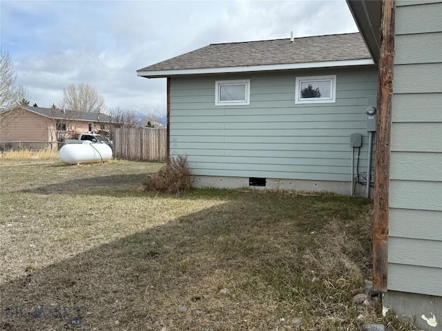 view of side of property with fence and a lawn