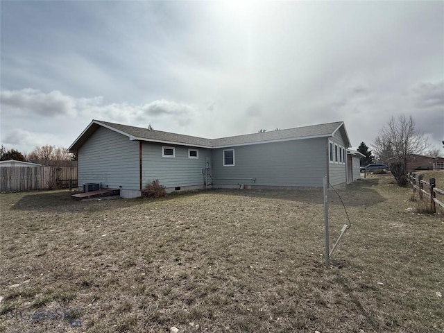 rear view of property with fence, central air condition unit, and crawl space
