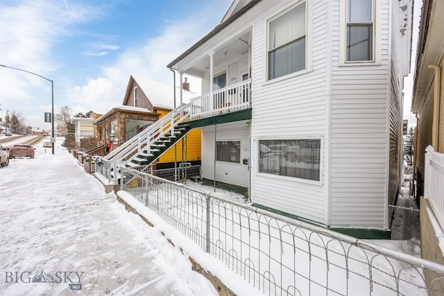 snow covered property with a balcony